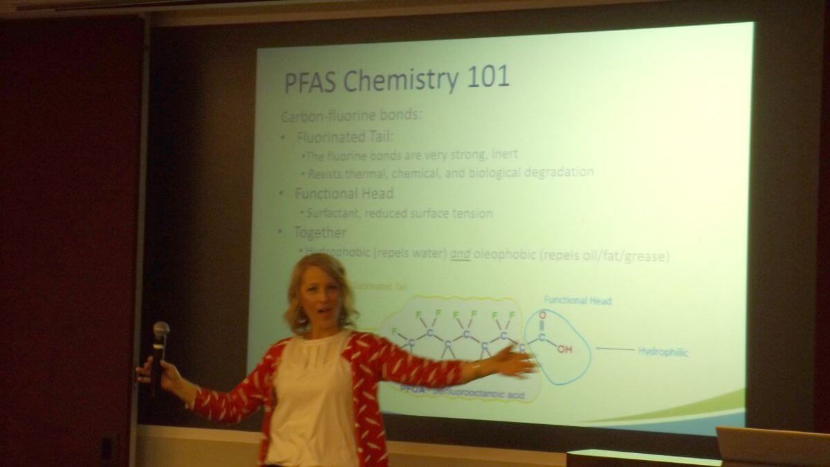 Image of speaker in front of "PFAS Chemistry 101" presentation. 
