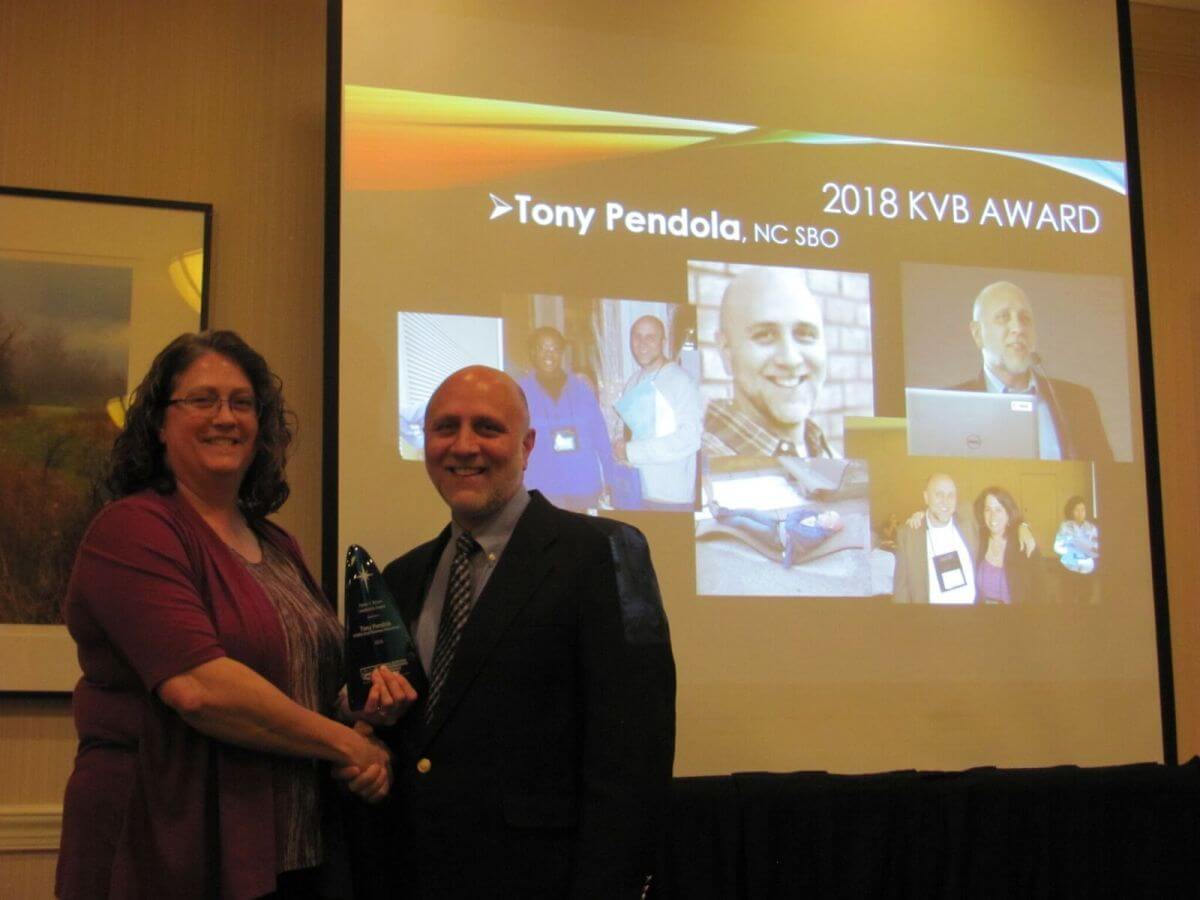 Image of Karen Brown award recipient holding up a award.