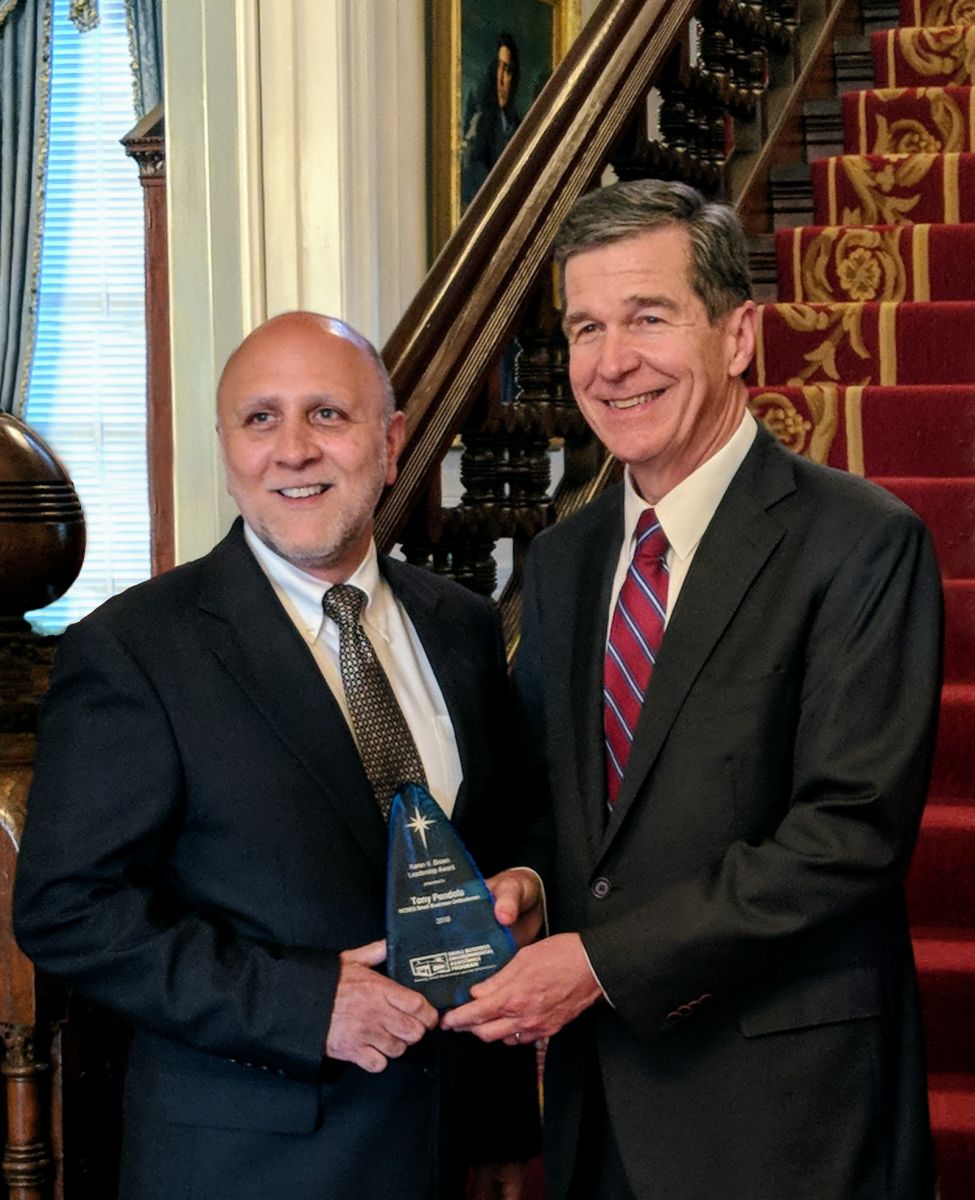 Tony Pendola, N.C. SBO and National Steering Committee Chair posing with N.C. Governor Roy Copper for picture with award.