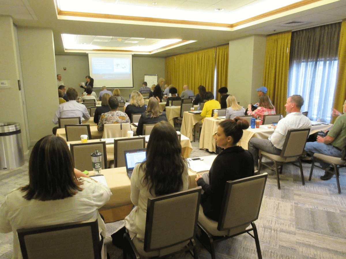 Image of conference attendees watching a presentation